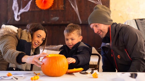 A family carving a pumpkin at Allan Bank, Cumbria